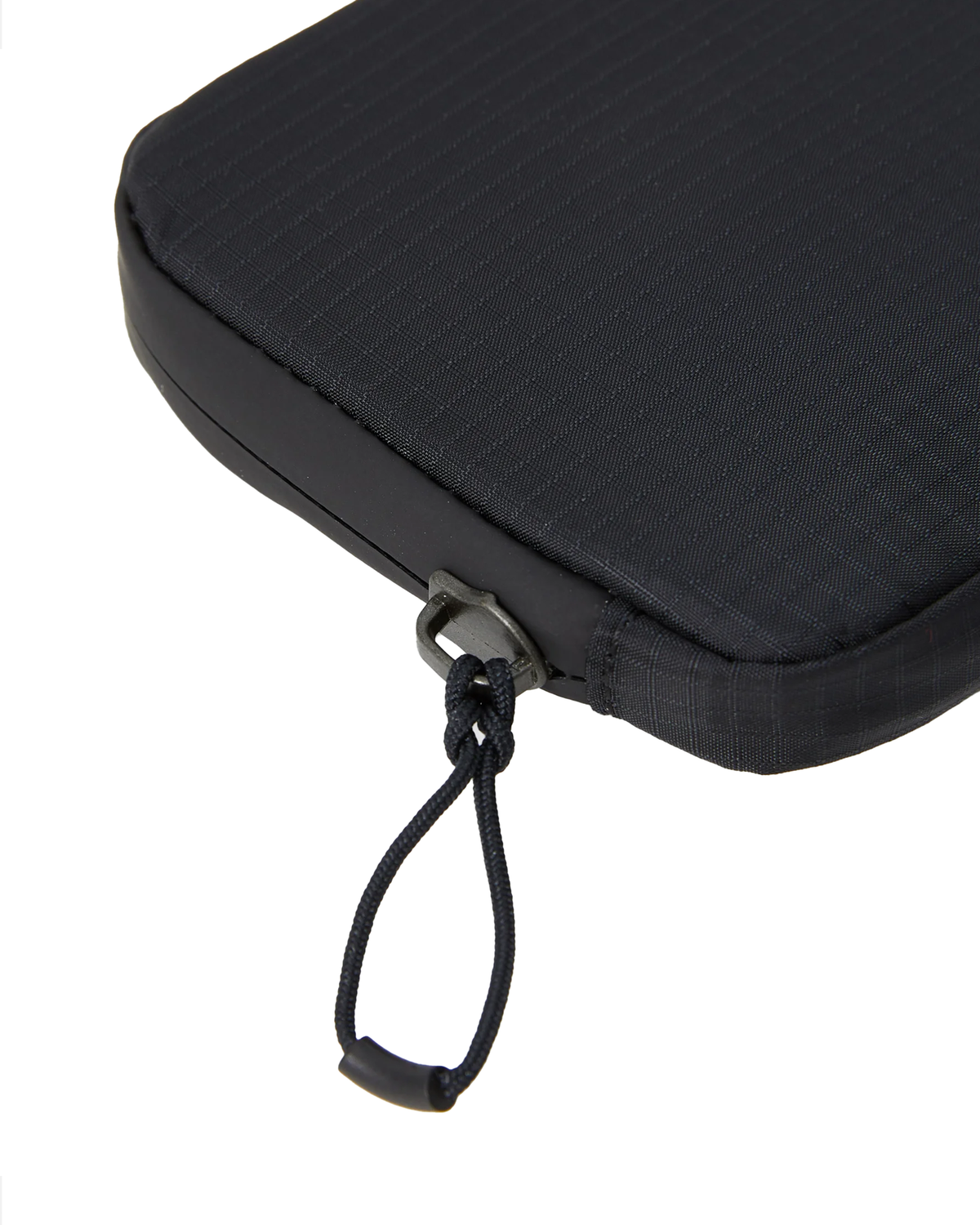 Close up of the corner of the Salomon ACS Essentials Case in black, showing the ripstop weave, the bonded edge trim and the zip slider with its knotted cord pull
