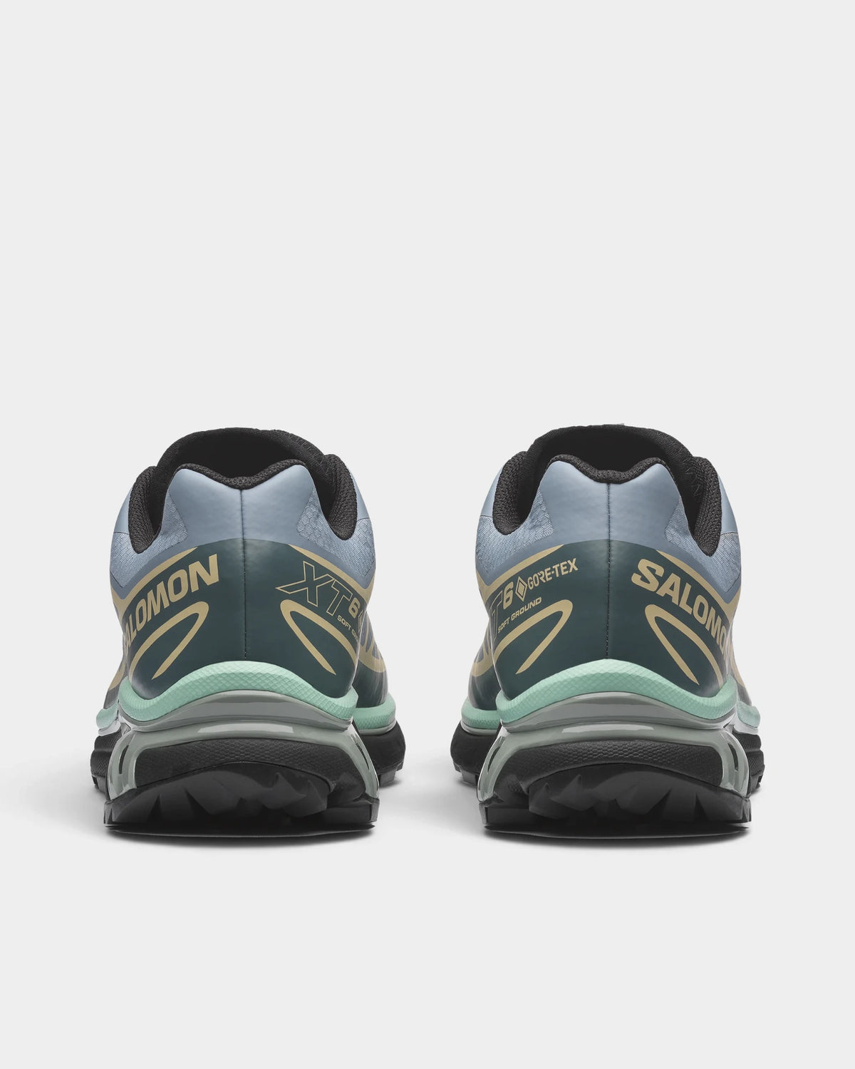 Salomon XT-6 Gore-Tex Shoes in Tradewinds/Stormy Weather/Bog, both shoes from behind, showing the light blue-grey upper with sand overlays and dark green accents on a black sole