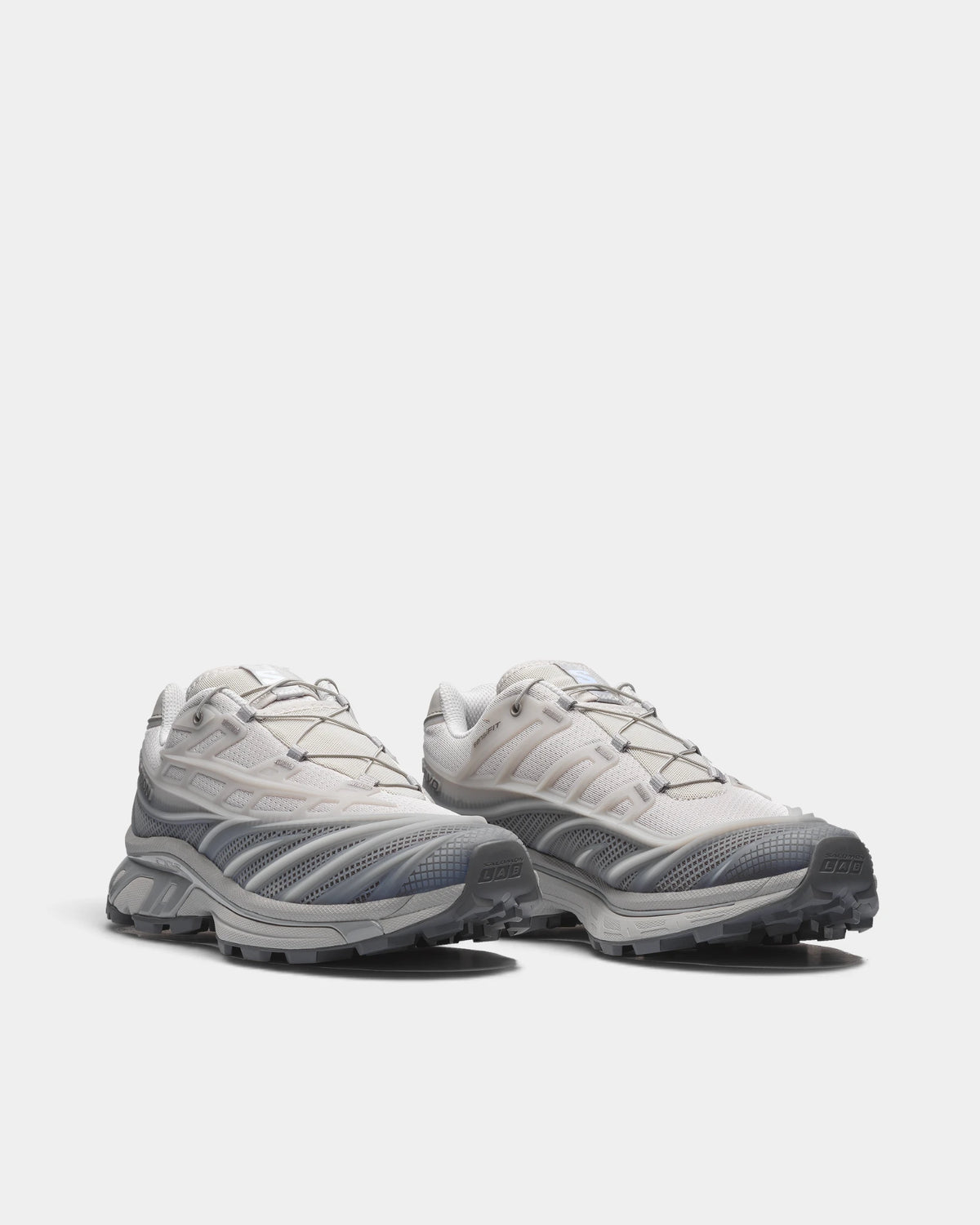 Salomon XT-EVO Shoes in Alloy/Castlerock/Footwear Silver, both shoes from a three-quarter front angle, showing the grey and silver layered upper on a grey sculpted sole