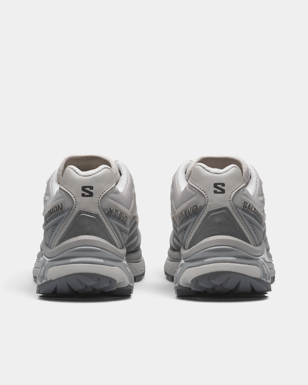 Salomon XT-EVO Shoes in Alloy/Castlerock/Footwear Silver, both shoes from behind, showing the grey and silver layered upper on a grey sculpted sole