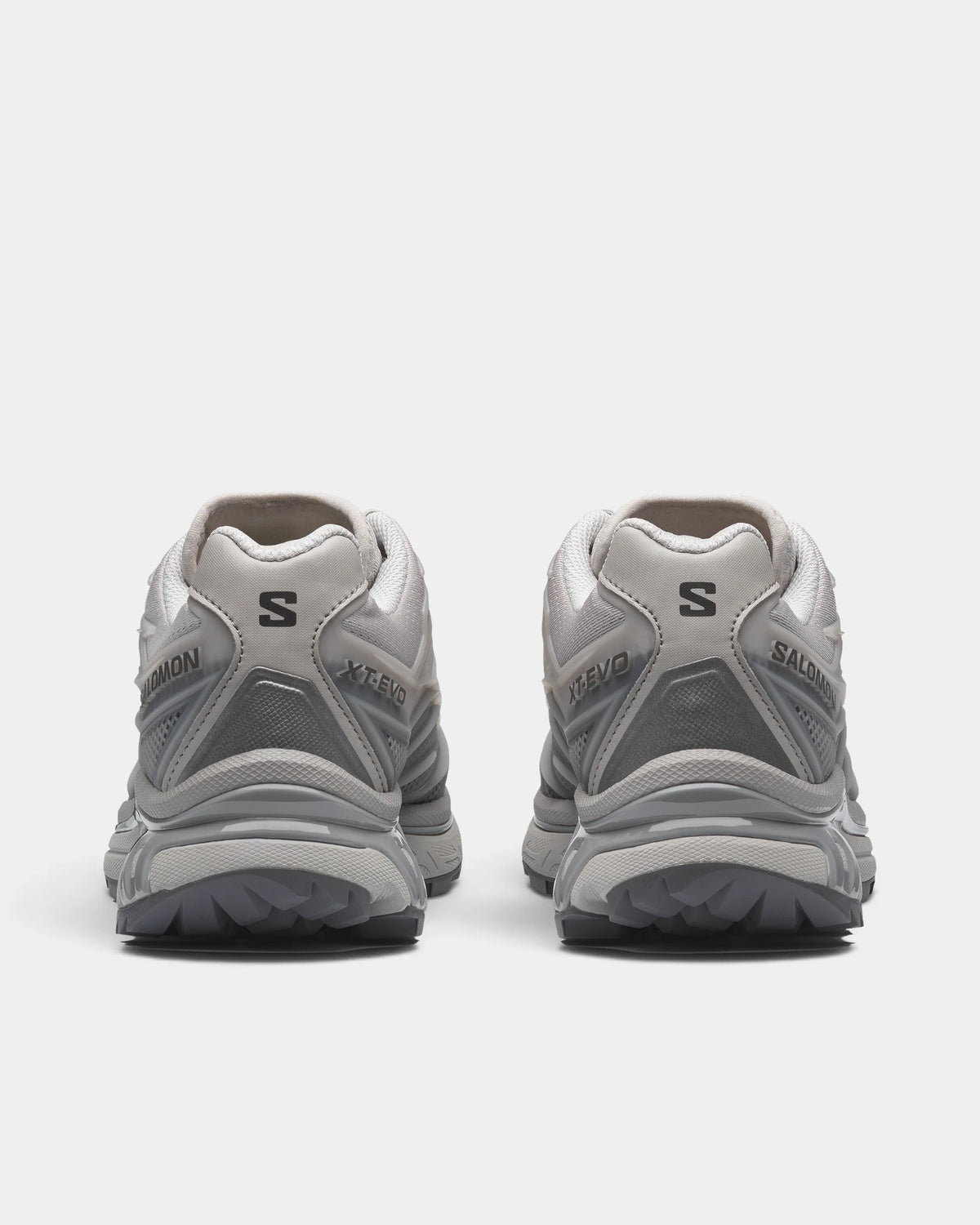 Salomon XT-EVO Shoes in Alloy/Castlerock/Footwear Silver, both shoes from behind, showing the grey and silver layered upper on a grey sculpted sole