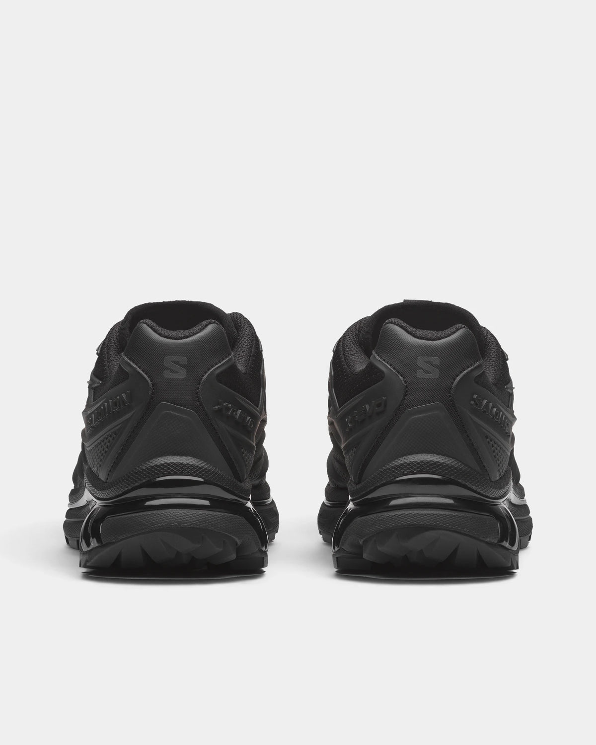 Salomon XT-EVO Shoes in Black/Black/Asphalt, both shoes from behind, showing the all-black layered upper on a black sculpted sole
