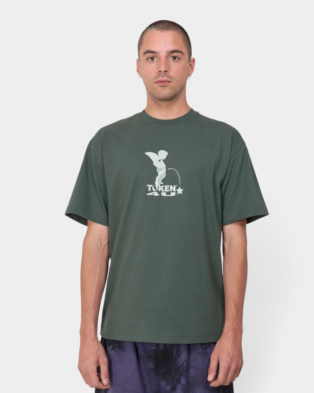 Lockwood Avenue Token Angelic t-shirt in midnight green with a pale winged cherub print, worn by a model, front view with tie-dye trousers
