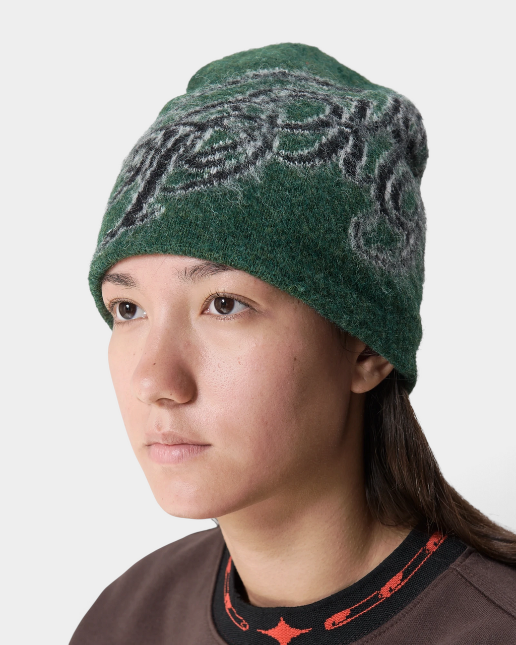 Lockwood Avenue Token Bae beanie in dark green with a dark jacquard scribble pattern, worn by a model