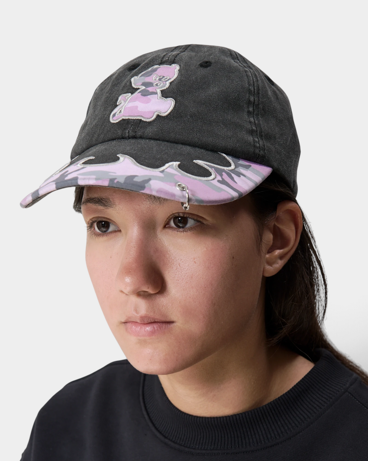 Lockwood Avenue Token Bae cap in washed black with a pink camo brim and a pink embroidered patch, worn by a model