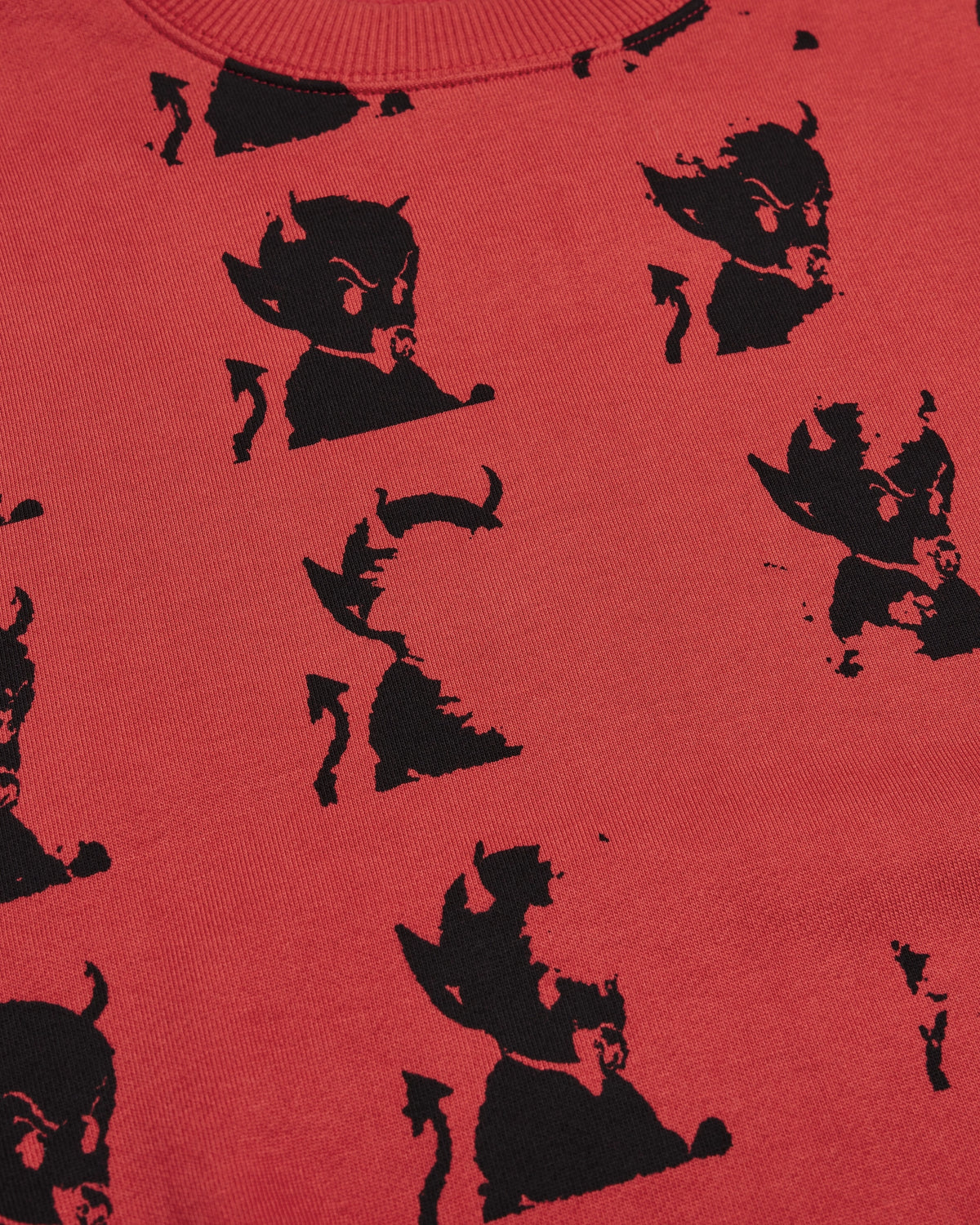 Lockwood Avenue Token Layback crewneck sweatshirt in red with an all-over black devil print, close up of the black devil print