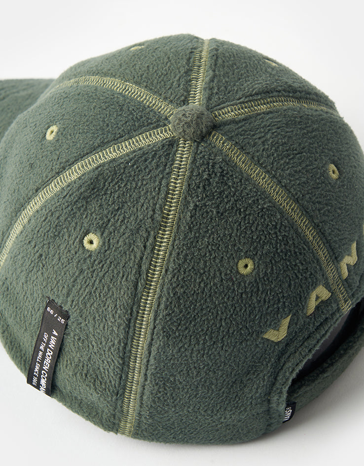 Vans Doren Curved Bill Jockey Cap in Pine Forest green seen from above, showing the six-panel fleece crown with contrast overlock seams and a covered button at the centre