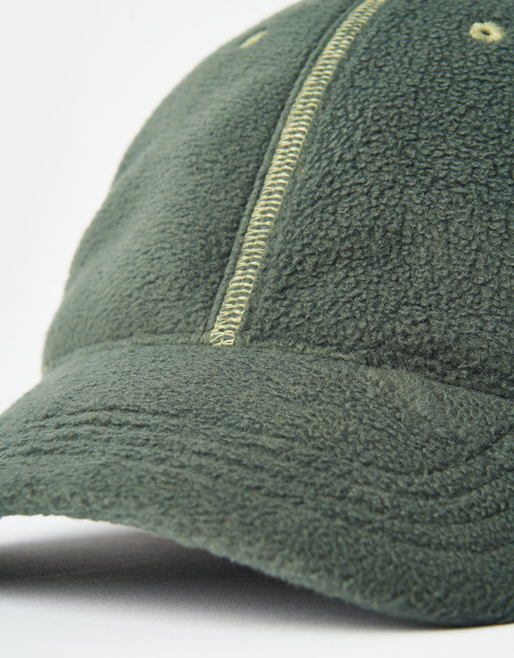 Close up of the Vans Doren cap's curved fleece bill and the pale contrast overlock stitching running down a panel seam