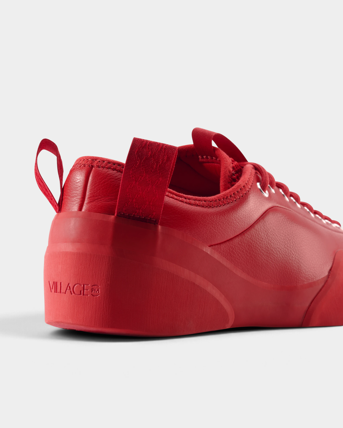 Village PM 1PM Full Grain Leather Shoes in Red: an all red full grain leather low-top skate shoe with red laces and a red sole, seen from behind at an angle, the heel and the side of the upper