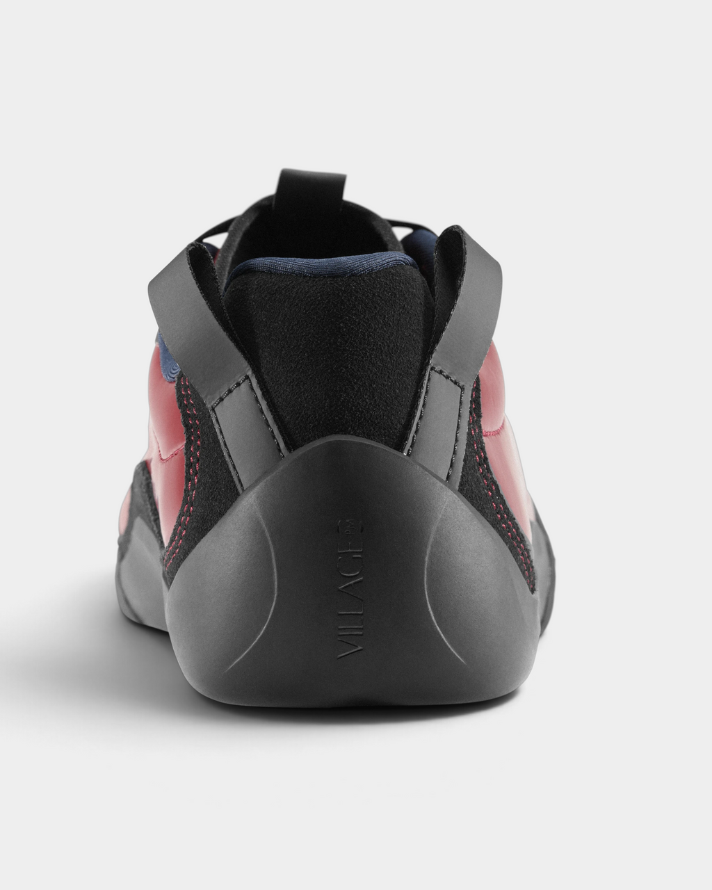 Village PM 2PM Synth Leather Shoes in Red/Natural Black: a red perforated leather low-top skate shoe with black overlays and a black sole, seen from behind, the heel and the pull tabs