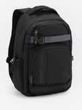 Volcom Everstone Backpack in black, three-quarter front view showing the grey skate strap with branded clip across the front, the embossed VOLCOM wordmark on the lower zip pocket and the side water bottle pocket